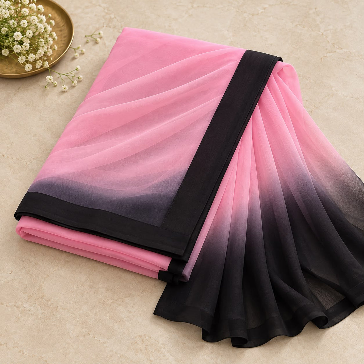 Pink georgette saree folded with black contrast edge