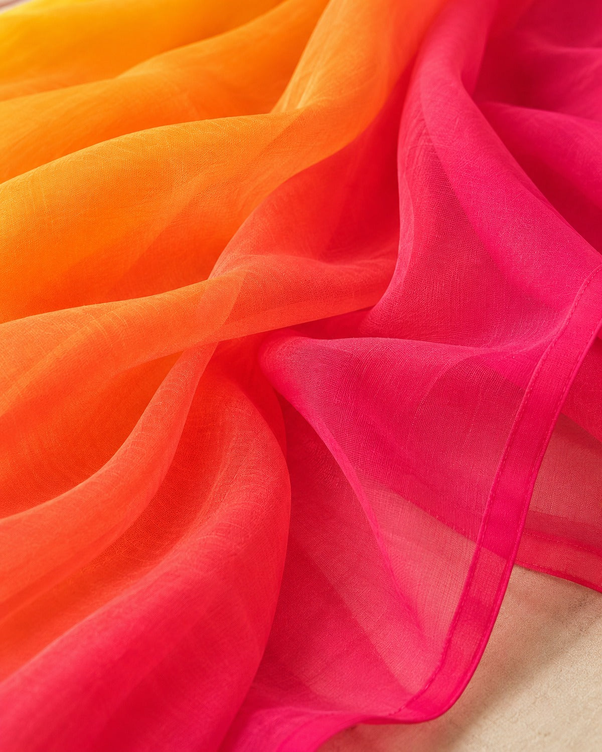 Close detail of the sheer georgette fabric where the orange ombre runs into hot pink