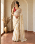 Ivory shimmer chiffon saree with gold butti motifs and mirror lace border, worn with the contrast red blouse