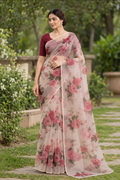 Model draped in a white floral printed organza saree with a narrow gold border and deep maroon blouse, photographed in a garden