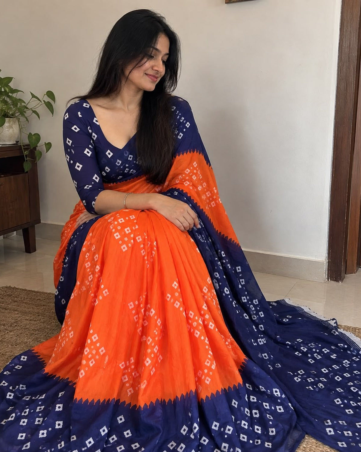 Orange banarasi silk bandhani saree with navy blue blouse, worn