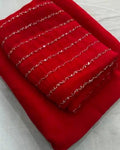 Red crush saree with gold zari stripes, folded with blouse piece
