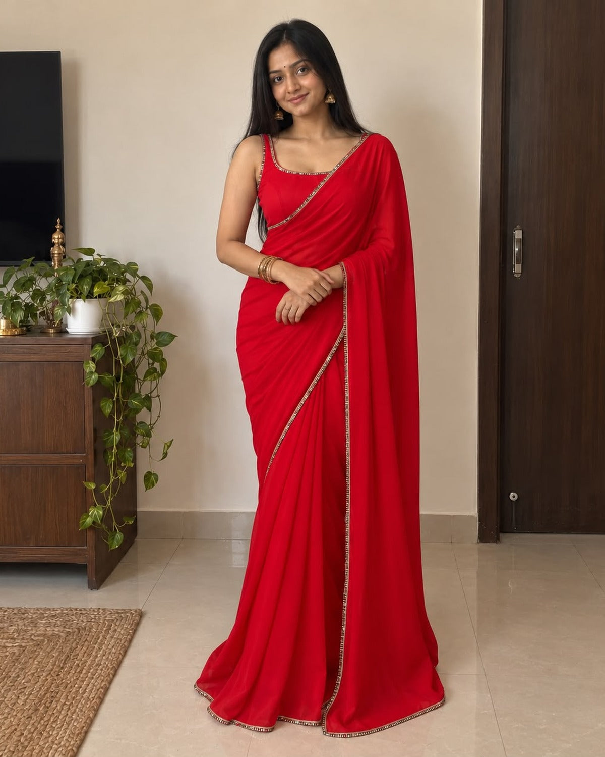 Red georgette saree with mirror work lace border, worn