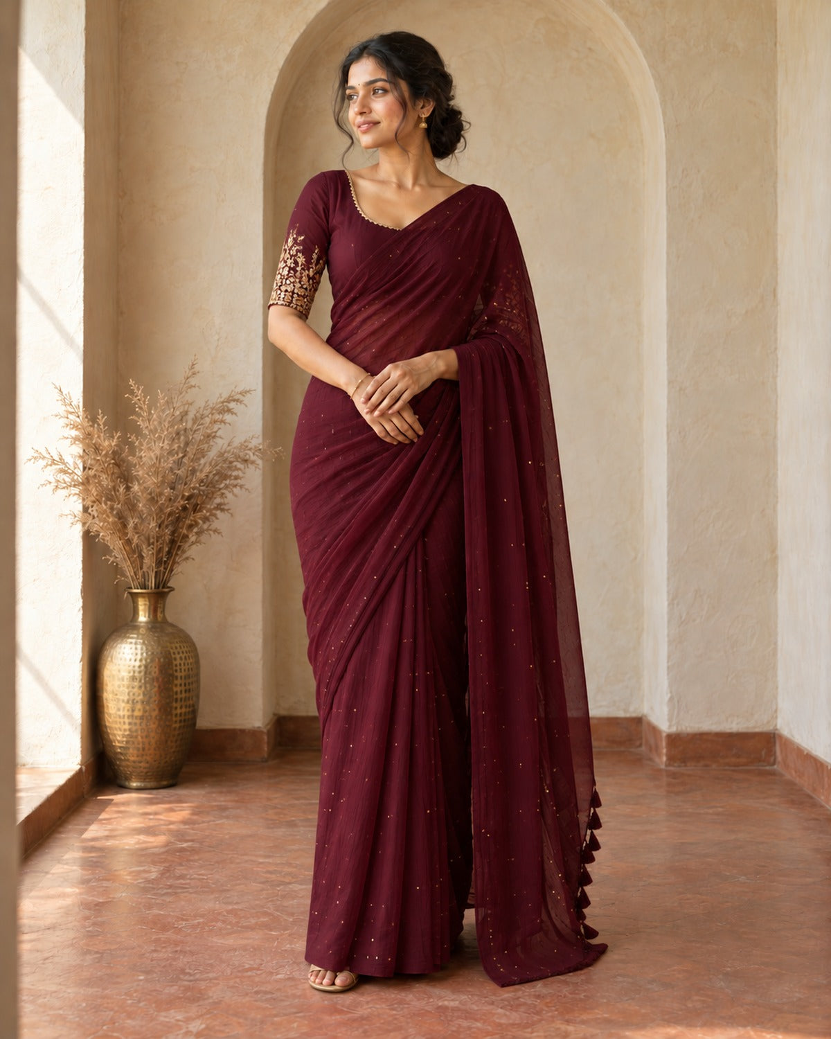 Wine chiffon saree with gold sequin dots and black tassel pallu border, worn